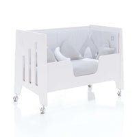 Cuna colecho OMNI blanca con barrera para camita infantil vestida con chichonera y nórdico estampados color verde